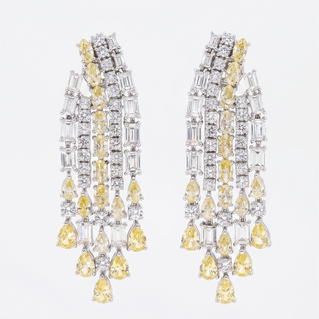 Pair of chandelier earrings with yellow and clear gemstones on a white background